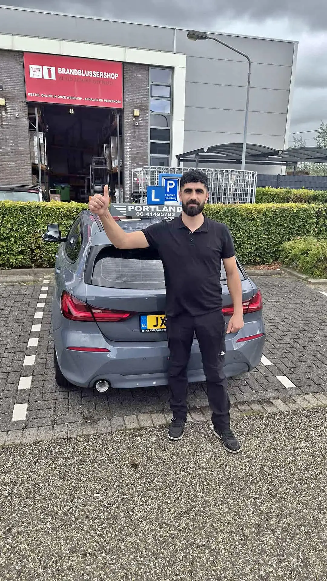 Rijinstructeur geeft een duim omhoog voor een lesauto met lesdak